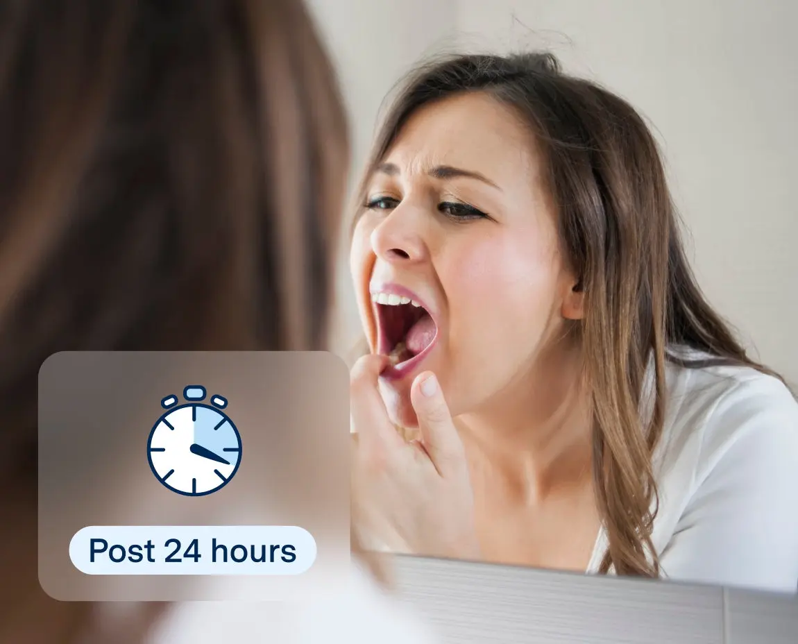 Woman inspecting her mouth in a mirror 24 hours after a tooth extraction, emphasizing post-extraction care and healing guidance provided by Aspen Dental.
