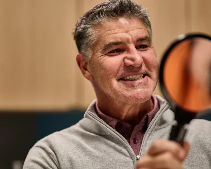 An Aspen Dental patient smiles into a mirror.
