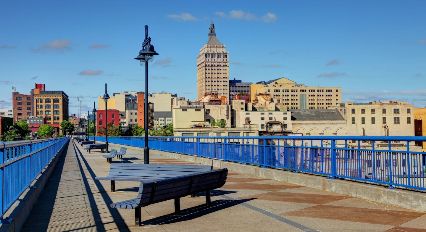 A view of a walkway in Rochester, New York, with buildings in the background, at midday