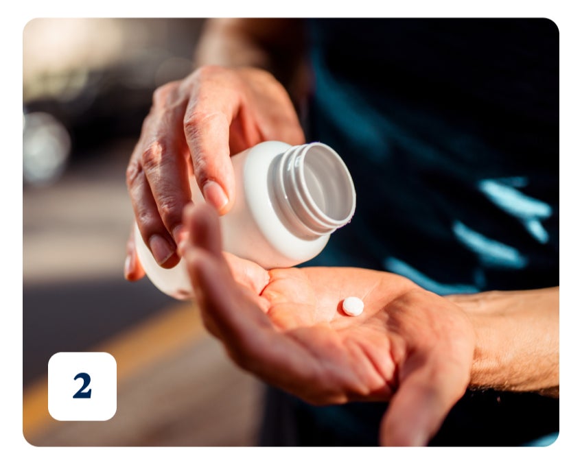 A photo of someone holding a pill bottle, pouring out one white pill into the palm of their hand.