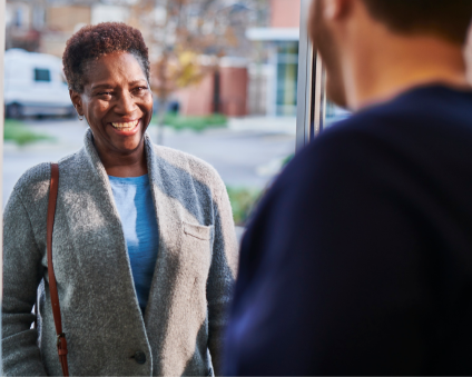 An Aspen Dental patient smiles as she walks into an office.