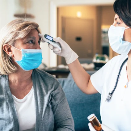 An Aspen Dental Doctor takes a patient's temperature. 