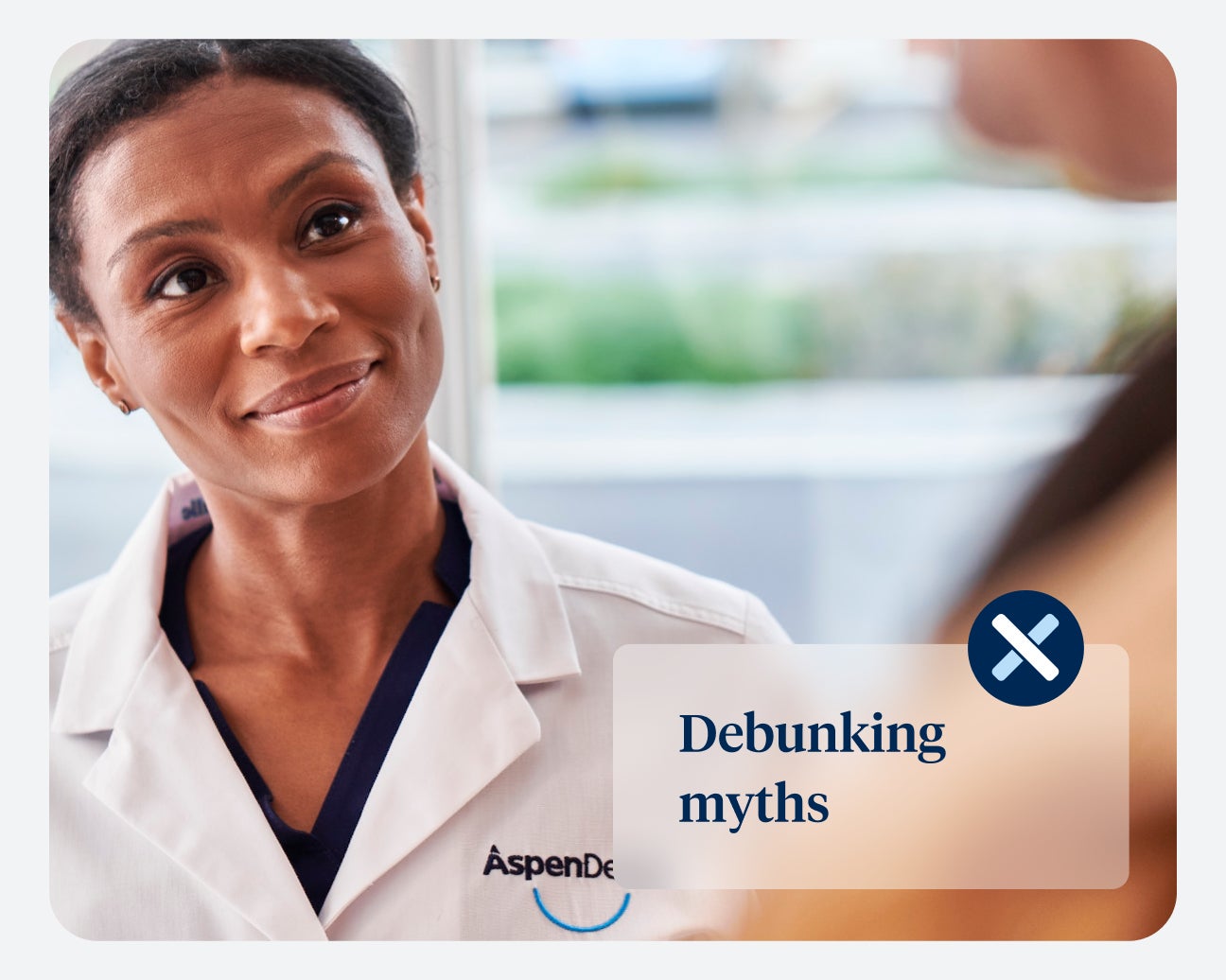 A professional in a white coat, labeled "Aspen Dental," looks attentively at someone. The image is overlaid with the text "Debunking Myths" alongside an icon of an 'X'.