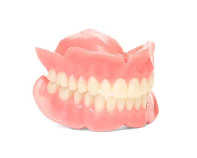 Classic full dentures with a complete set of white teeth, pink gums, on white background.