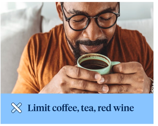 A person wearing glasses and an orange shirt holds a cup of coffee close to his face, smelling the beverage inside. A caption below reads: "Limit coffee, tea, red wine" with a cross icon.
