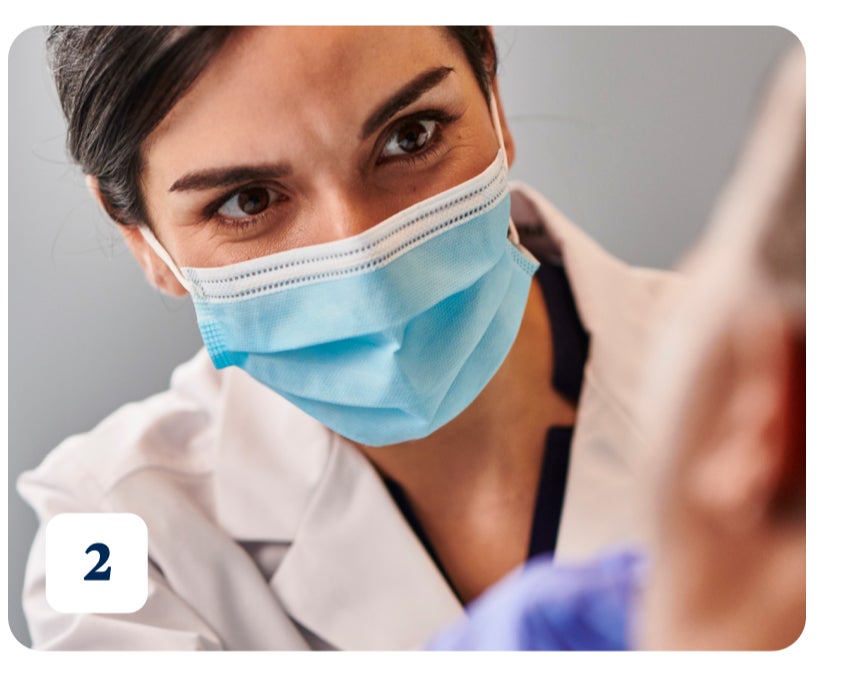 A healthcare professional wearing a blue surgical mask and white coat attentively looks at a patient. The number "2" is in the bottom left corner indicating the second treatment option for tooth abscess.