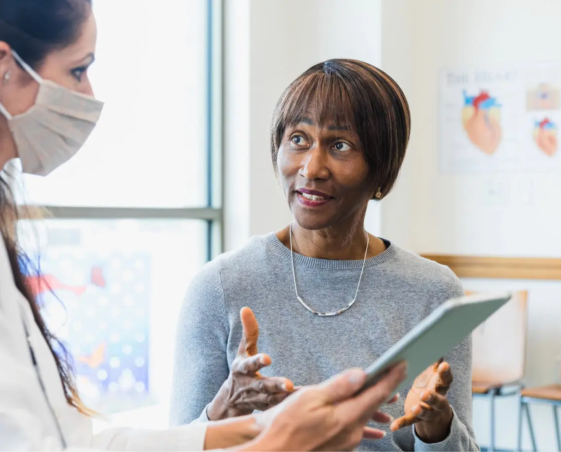 A patient speaks with a healthcare provider during a consultation, potentially discussing cold sore treatment options. Highlights the importance of professional advice on how to get rid of a cold sore quickly.