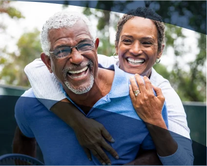 A couple smiles as one gives the other a piggyback ride.