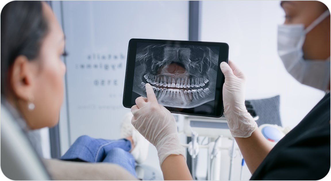A ClearChoice doctor evaluating the results of the 3D image scan of a patient and walking them through upcoming treatment procedures during their initial consultation.