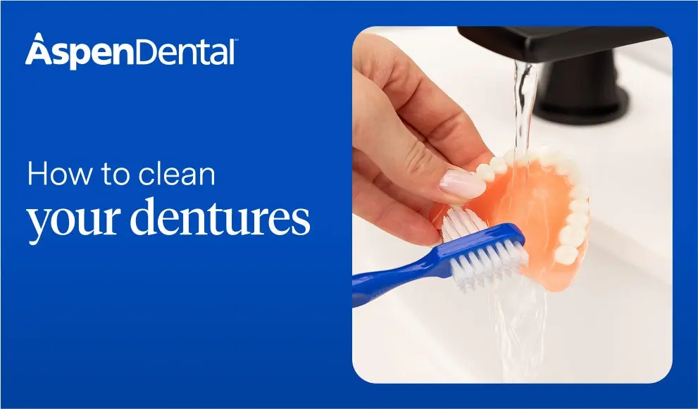  Cleaning dentures with a soft toothbrush under running water – at-home denture hygiene care example.