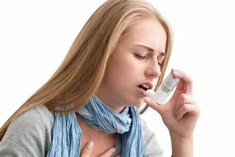 A young woman uses her asthma inhaler. 