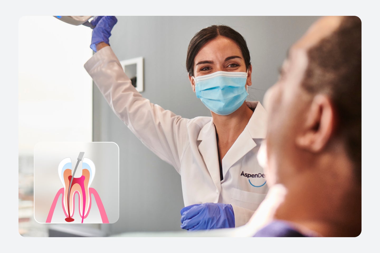 Dentist in a white coat and blue gloves holds a dental exam equipment, smiling at a seated patient. An inset diagram shows a root canal procedure.