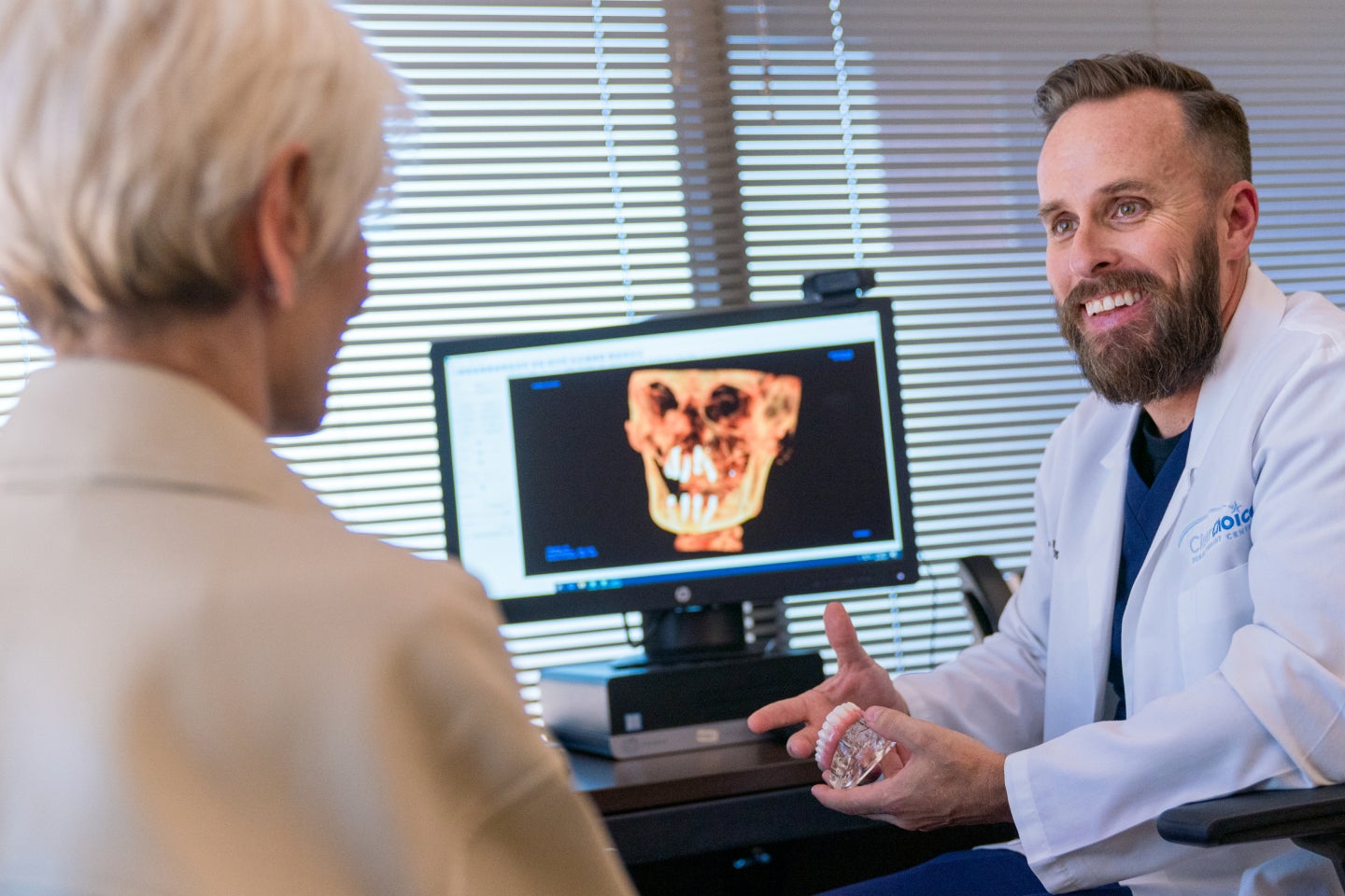 A ClearChoice dentist explaining the visual smile design X-ray, including the expected results and benefits, to his patient.