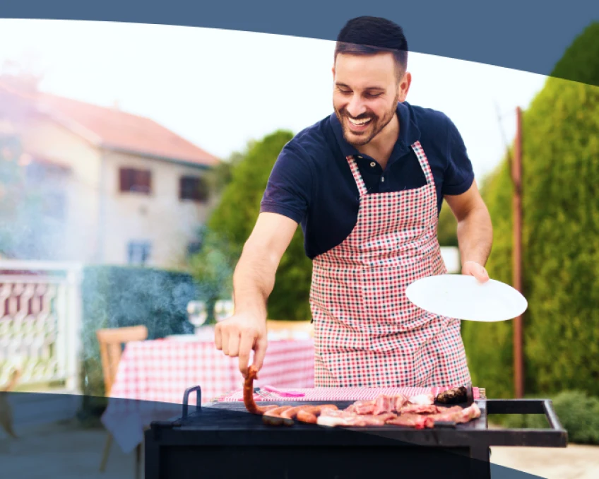 An Aspen Dental patient grills hotdogs in their backyard.