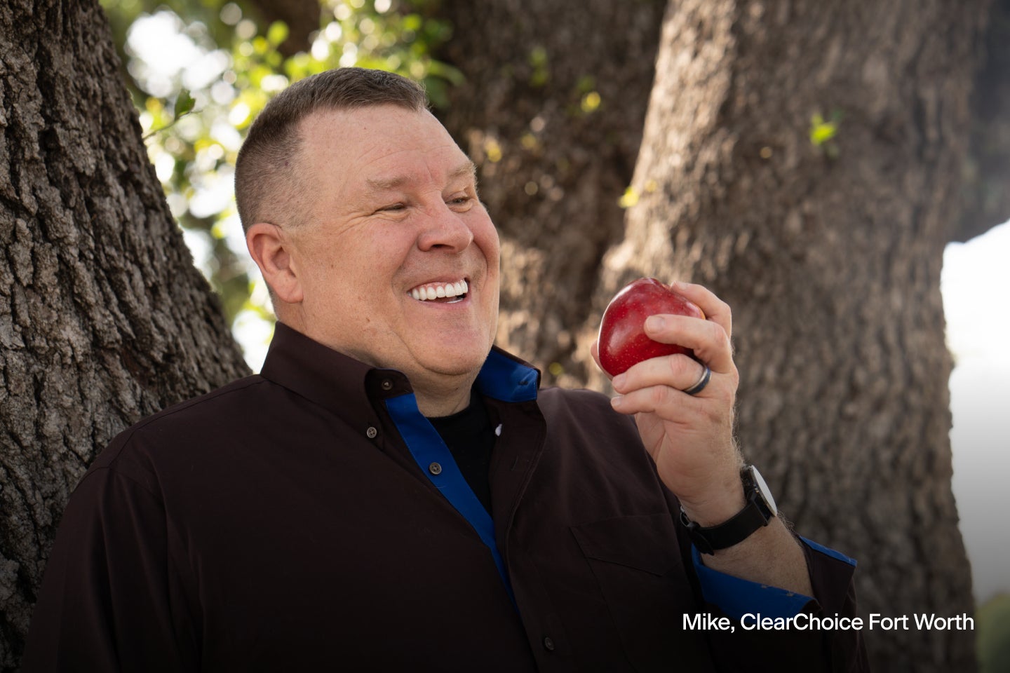 An image of Mike, a ClearChoice dental implant patient from Forth Worth, eating an apple. He's showcasing his improved eating functionality.