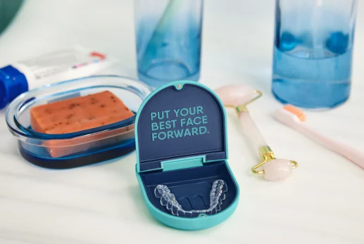 Motto Clear Aligners case sitting on a bathroom countertop.