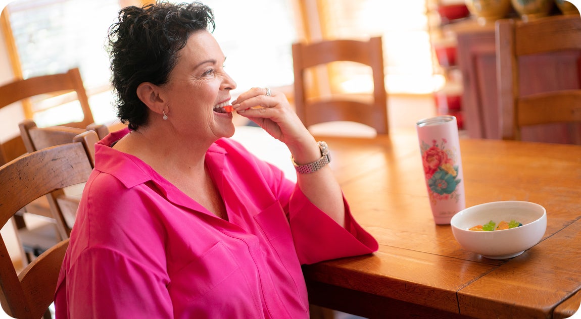 A female patient enjoying her favorite foods again after receiving her full set of dental implants from ClearChoice.