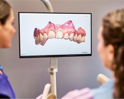 An Aspen Dental doctor and patient look at scans together. 