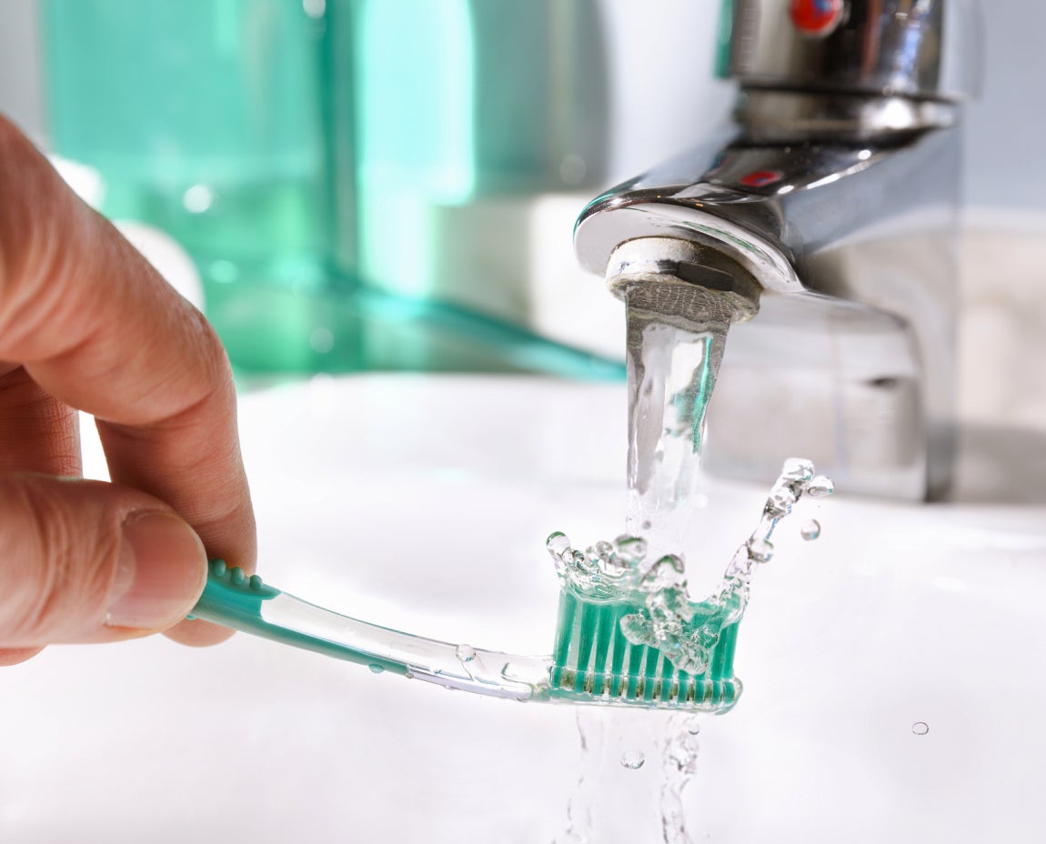 Close-up of a hand rinsing a green toothbrush under running water from a bathroom faucet, illustrating a clean start to an oral care routine. The water splashes add a refreshing feel, aligning with Aspen Dental’s emphasis on hygiene and dental health.
Reply
