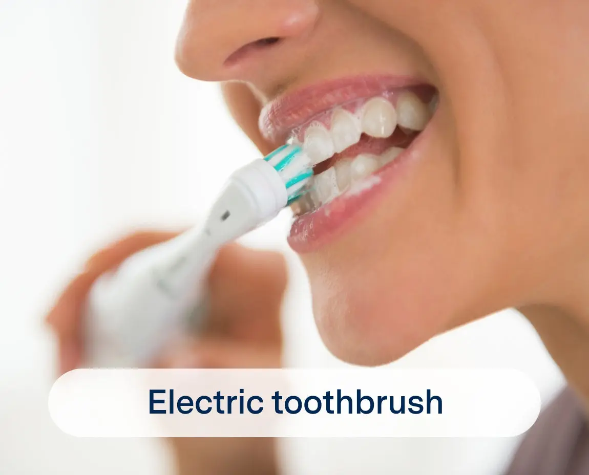 Close-up of a woman using an electric toothbrush to brush her teeth. The toothbrush bristles are in contact with the teeth, and the image displays a label reading "Electric toothbrush.