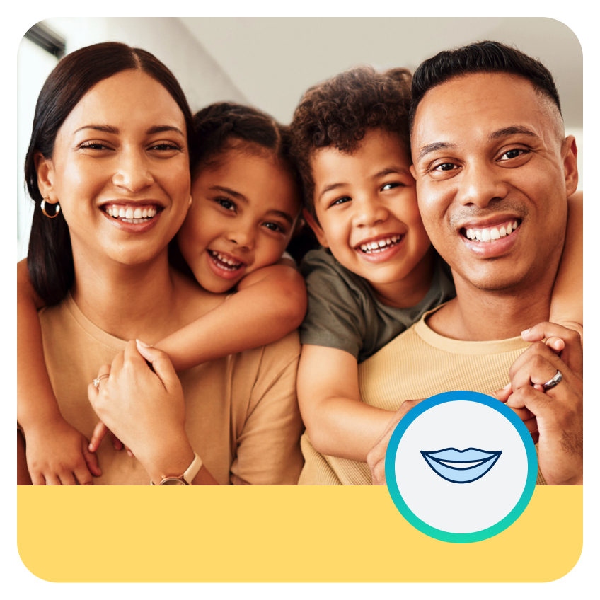 Una feliz familia, con un padre y una madre, todos con cabello negro, están sonriendo, junto con una niña y un niño.