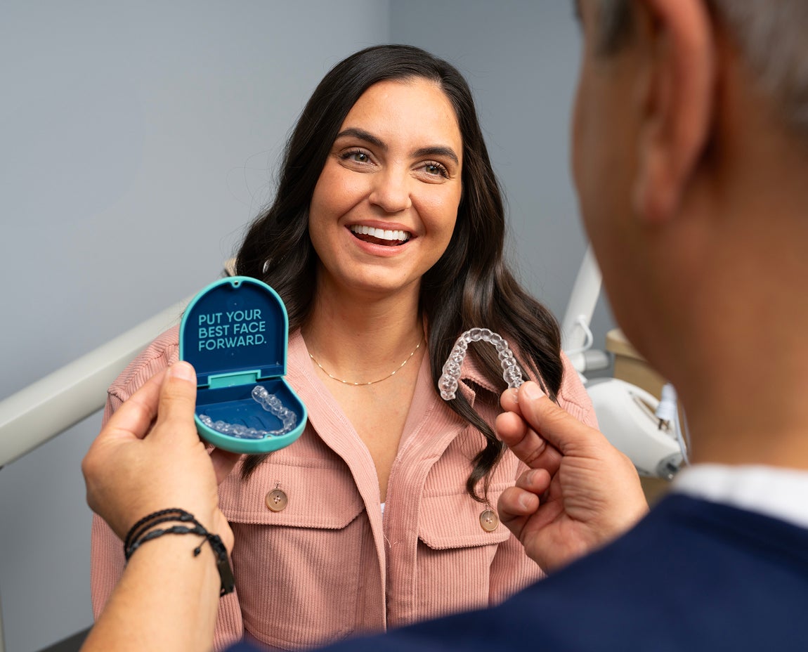 Woman receiving in-person provider care for her clear aligners at Aspen Dental, highlighting the benefit of regular check-ups with Motto.