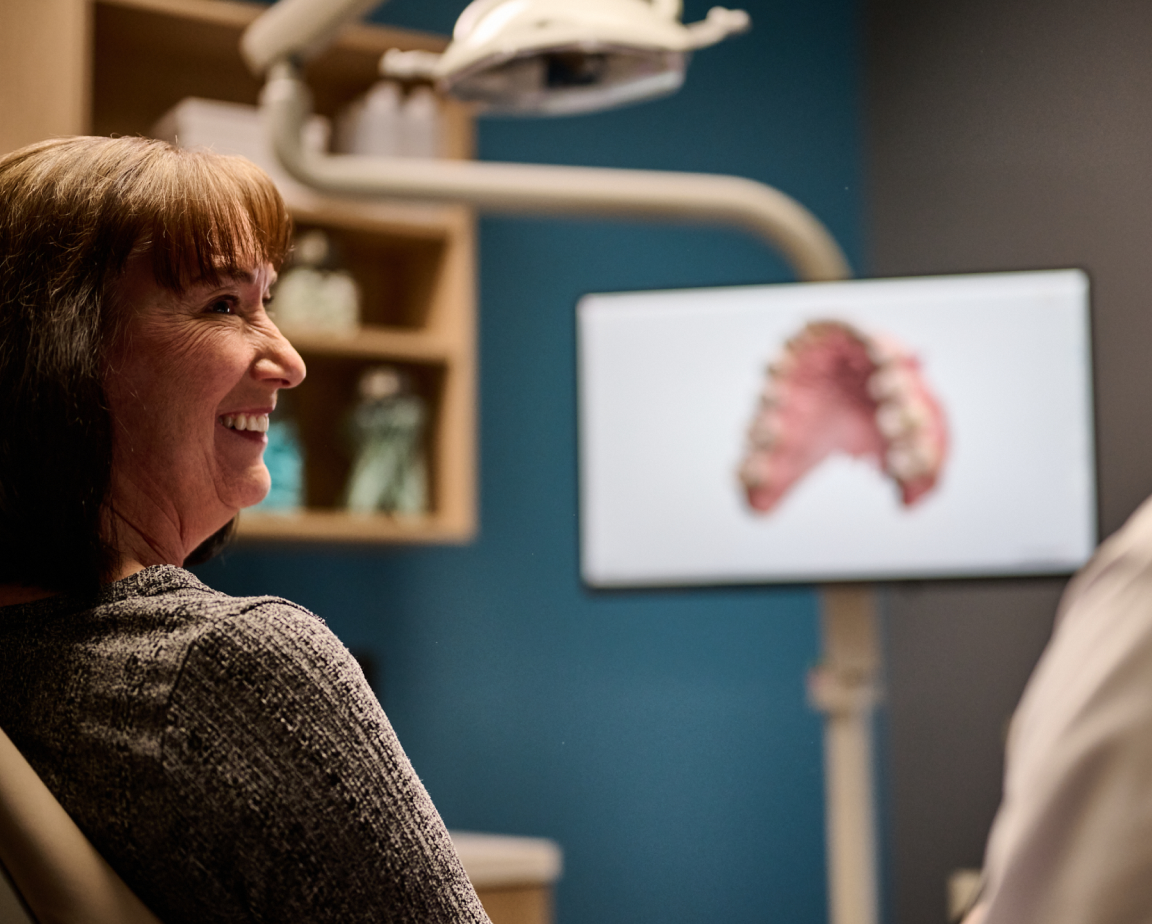 miling patient looking at dental x-ray results with dentist.