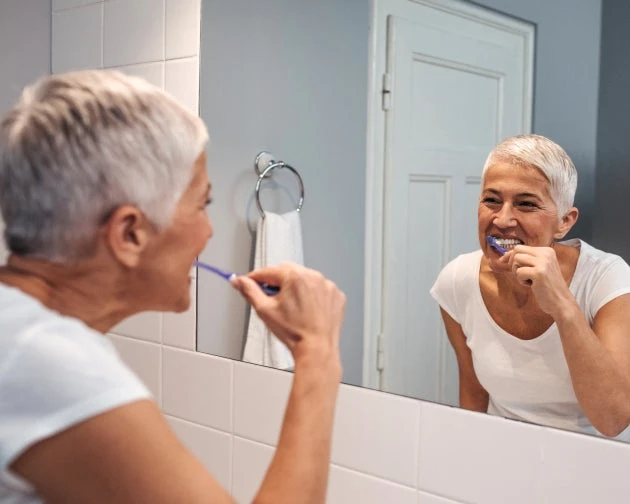 An image of woman brushing and flossing daily.