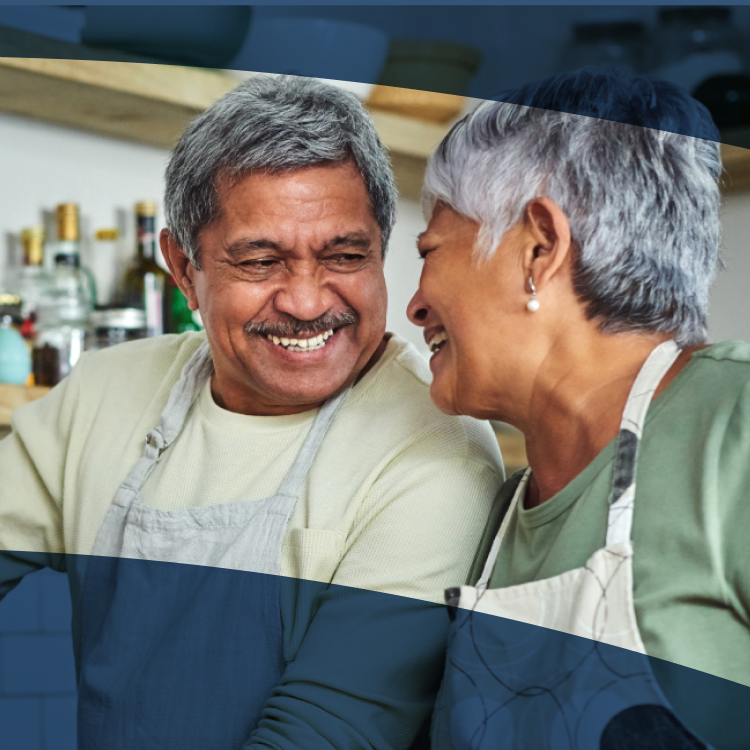 Image of a man enjoying cooking with his wife as he enjoys all of his favorite foods with implant dentures.