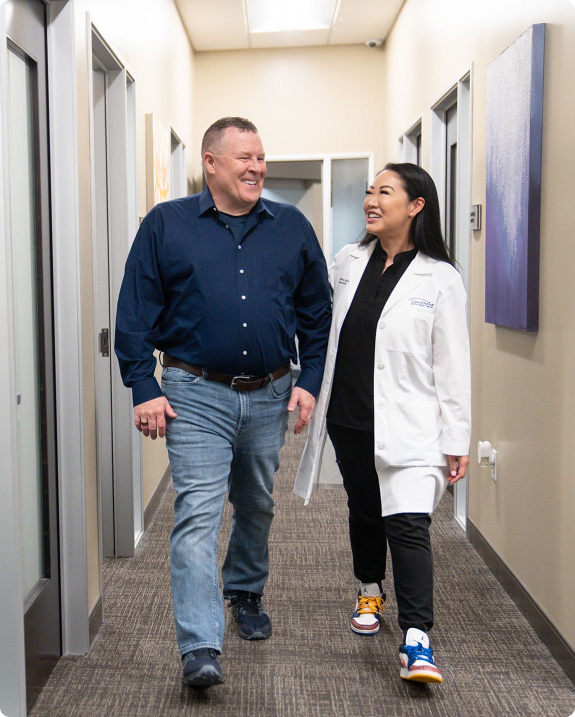 A ClearChoice doctor walking her patient out after he has completed his dental implants procedure and gained his confidence.