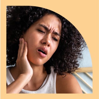 Person experiencing jaw pain, highlighting potential discomforts associated with orthodontic issues.