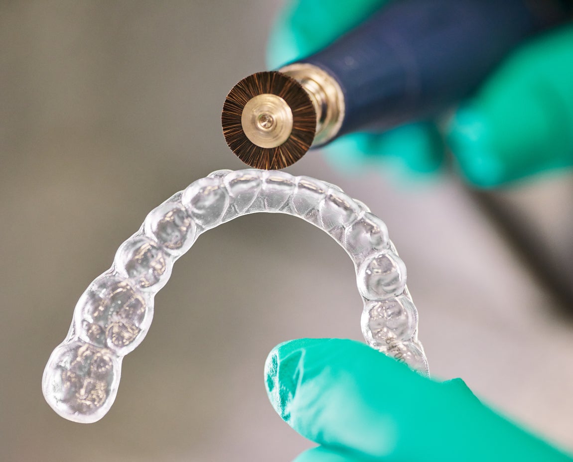 Dental provider holding Motto Clear Aligners, refining the fit to ensure a customized and comfortable treatment experience.
