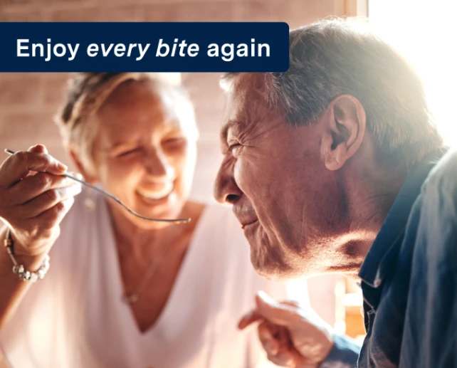 An older couple enjoying a meal together, savoring each bite, with the words "enjoy every bite again" on the image.
