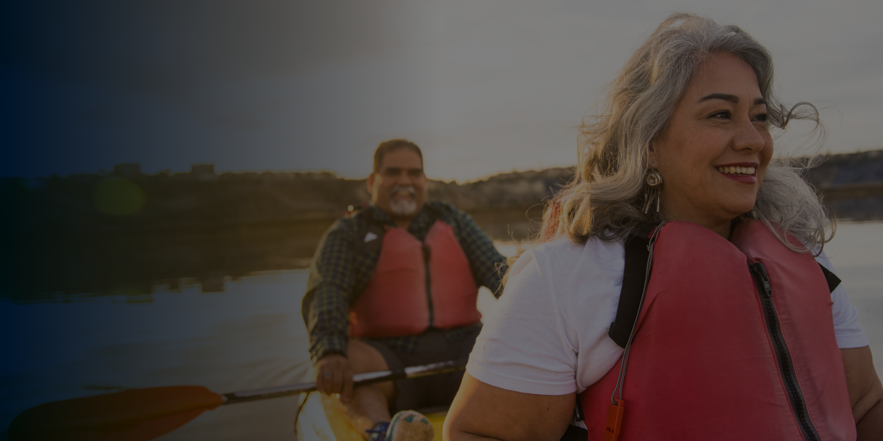 An Aspen Dental Implants couple smiles as they canoe together. 