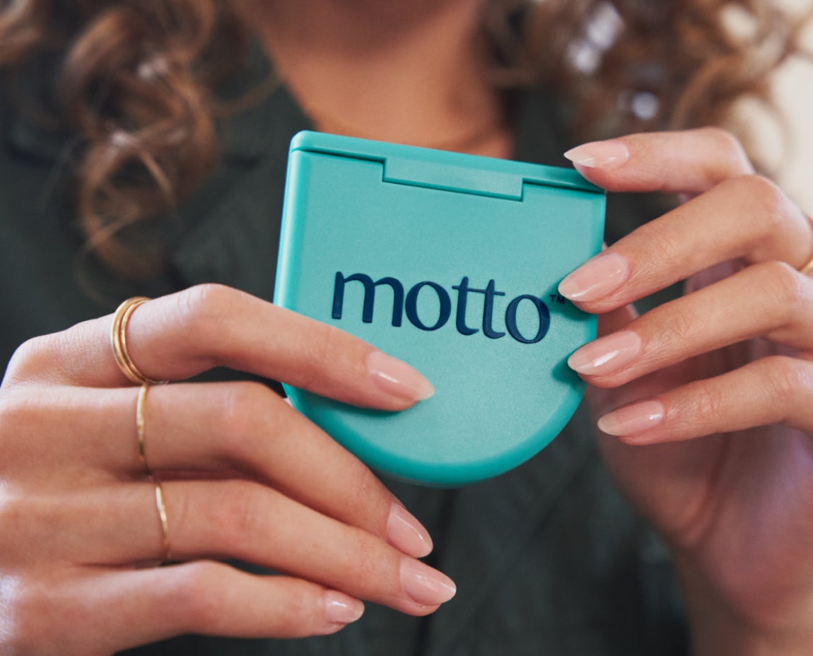 A woman holding Motto clear aligners case.