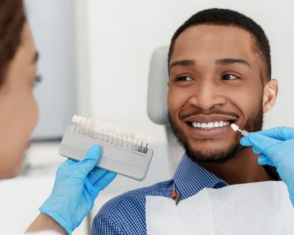 An Aspen Dental patient smiles as he selects new veneers. 