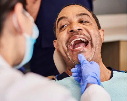 An Aspen Dental patient opens his mouth for an examination. 