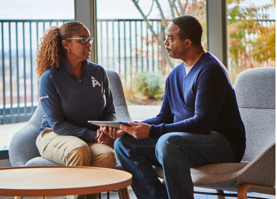 An Aspen Dental employee sits and discusses options with a patient. 