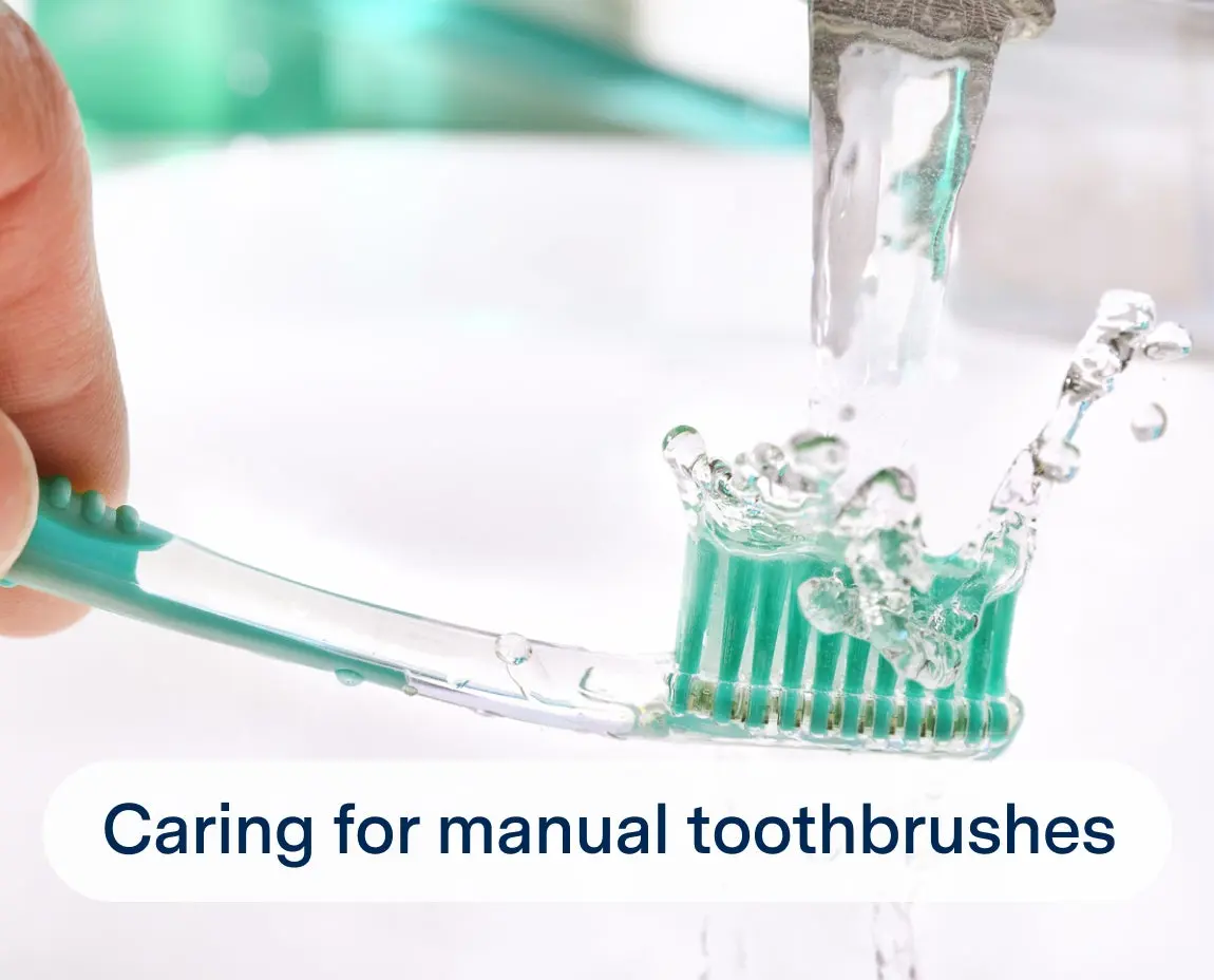 Close-up of a hand rinsing a manual toothbrush under running water, with the label "Caring for manual toothbrushes" at the bottom.