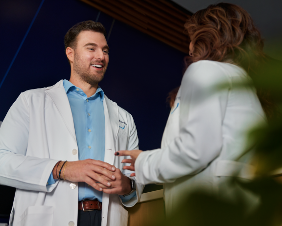 A male and a female Aspen Dental dentist engaged in a coversation