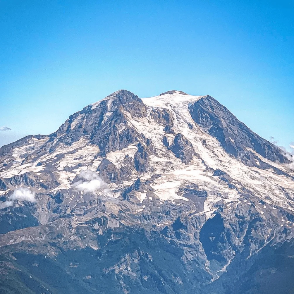 A mountain peak with a blue sky behind it.