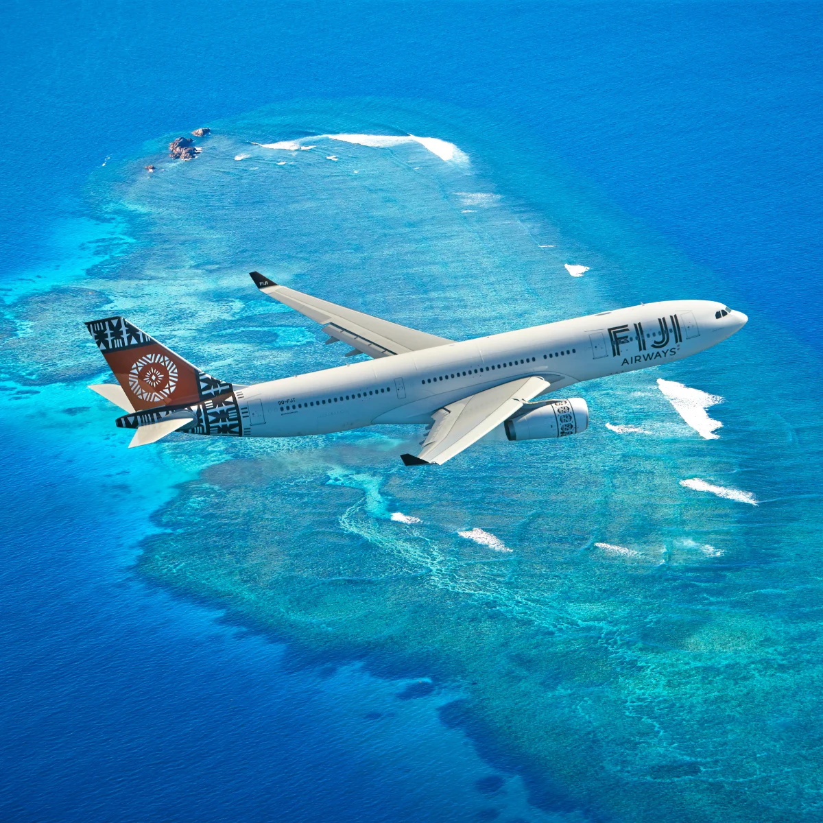 A Fiji Airways plane flies over an island surrounded by blue water.