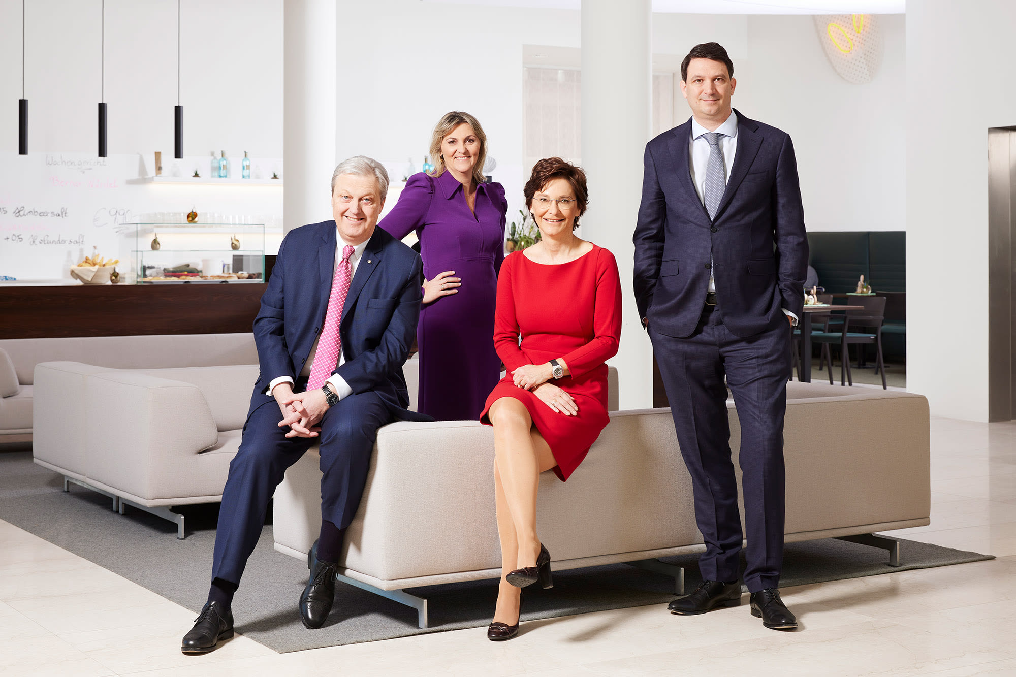 SI / Fotografija s štirimi člani uprave banke, ki sedijo na naslanjaču in pozirajo fotografu.