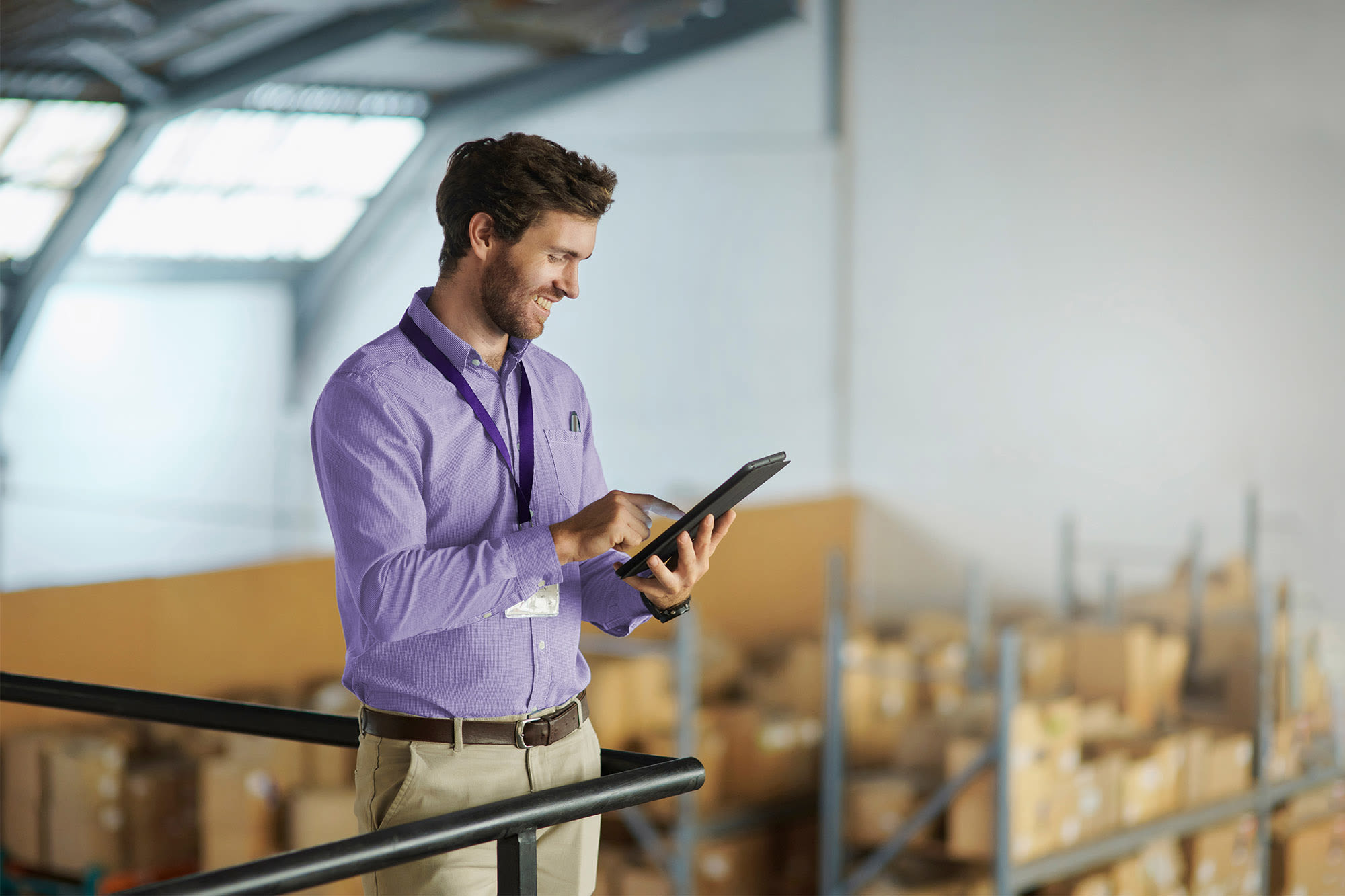Zaposleni v skladišču uporablja tablični računalnik - digitalni procesi pri poslovanju s strankami v podjetju.