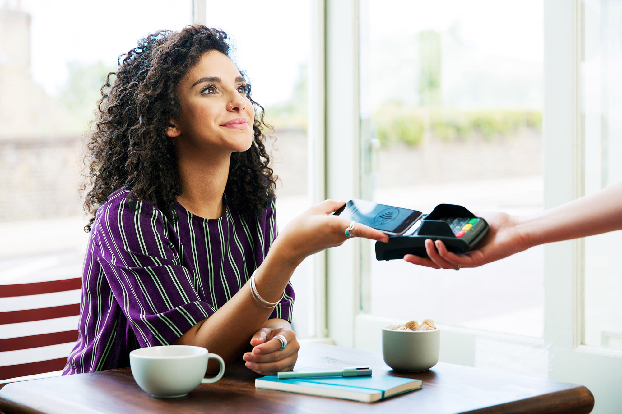 Frau zahlt mit Smartphone an Kartenlesegerät - Google Pay mit der BKS Bank
