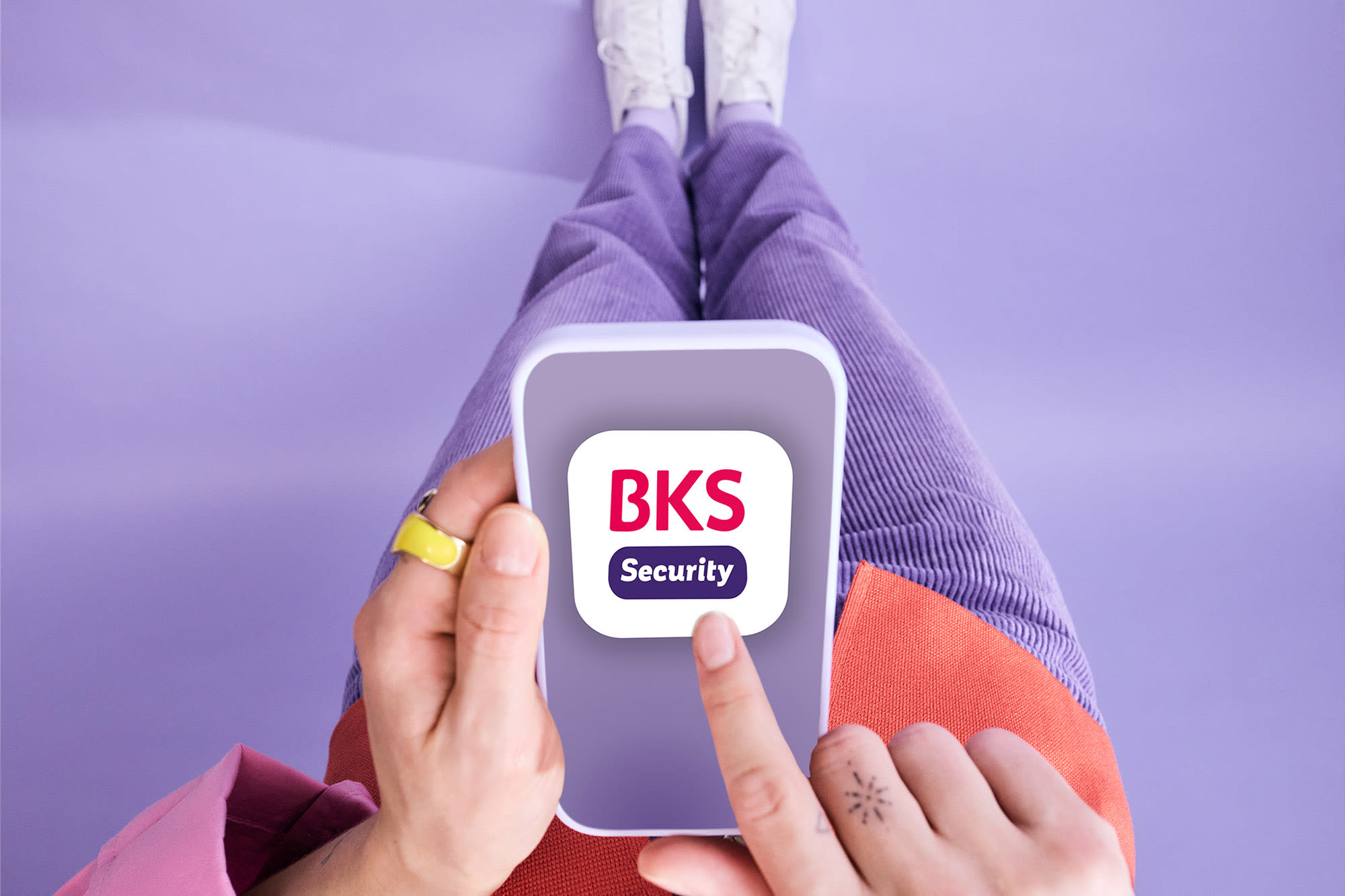 Finger zeigt auf Smartphone mit BKS Security App – sicheres Online-Banking mit BKS. Finger zeigt auf Smartphone mit BKS Security App – sicheres Online-Banking mit BKS.