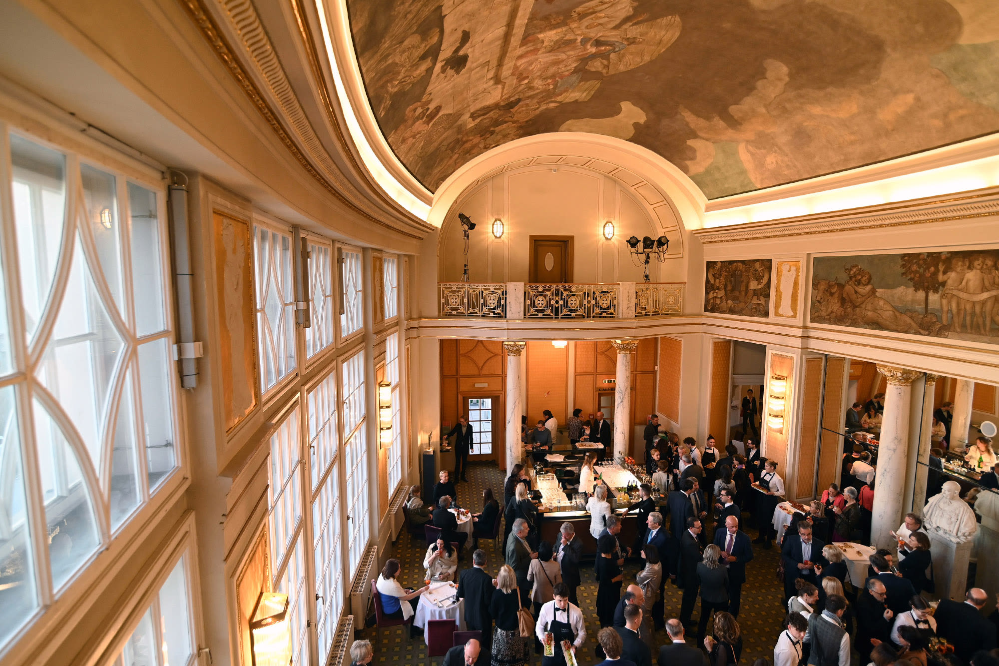 Dvorana, polna ljudi v v elegantnih oblačilih.