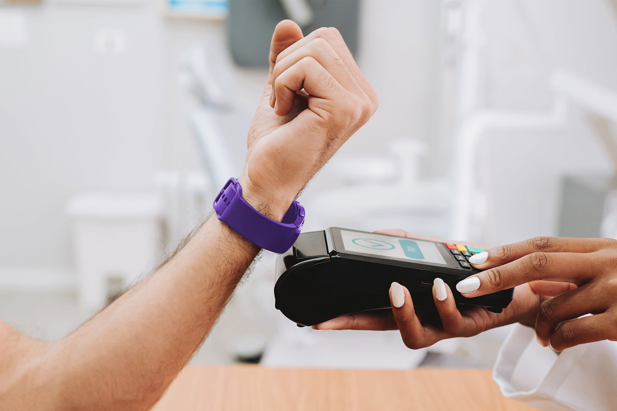 Mann zahlt mit Smart Watch an Kartenlesegerät - Swatchpay der BKS Bank Mann zahlt mit Smart Watch an Kartenlesegerät - Swatchpay der BKS Bank