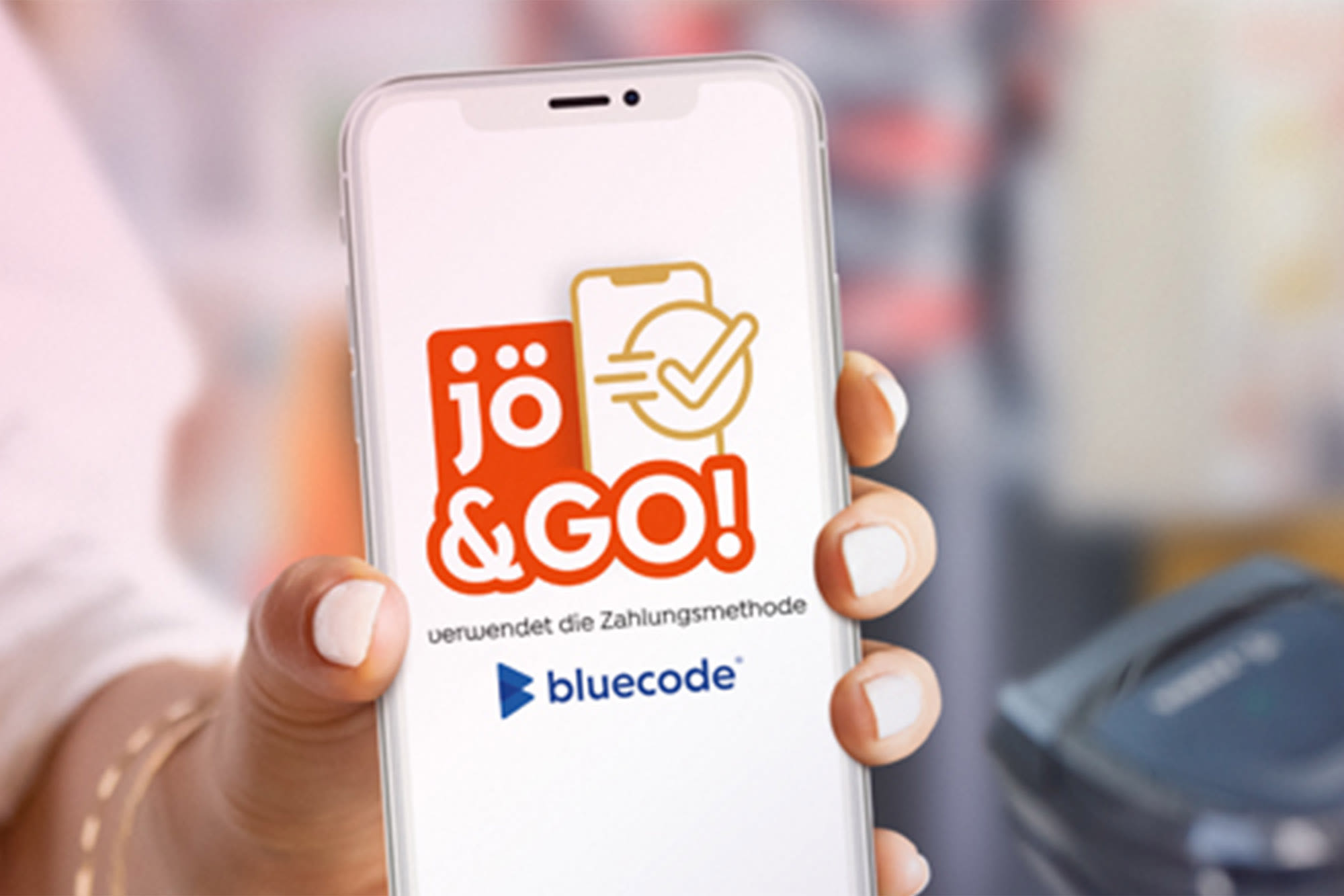 Frau hält Smartphone mit jö&GO Logo in der Hand. Frau hält Smartphone mit jö&GO Logo in der Hand.