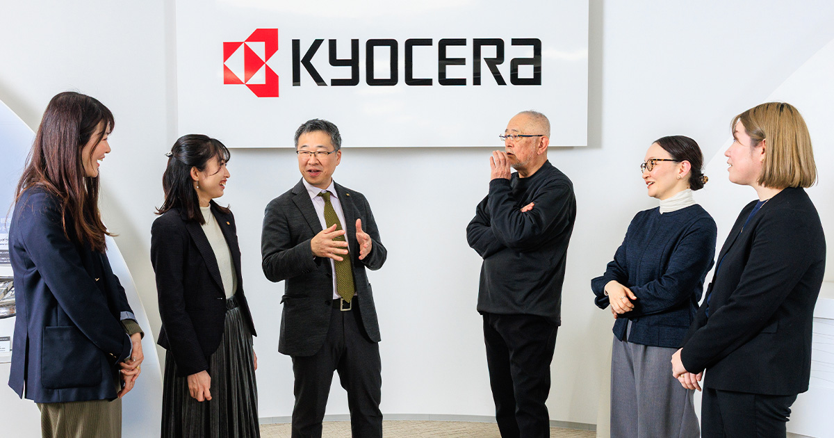 集合写真：京セラ様オフィスにて壁面コーポレートサインの前で、左から松田氏、篠原氏、北垣氏、橘、新山、三木が並び談笑する様子。